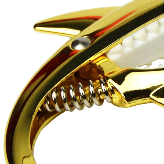 Close-up of rose gold shark capo clamp with serrated hinge teeth