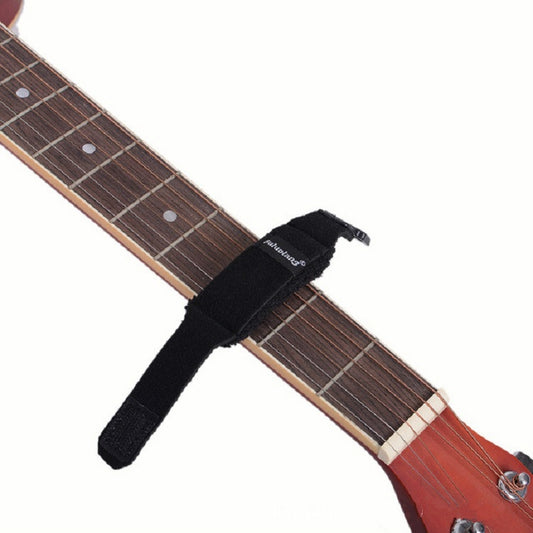 Black strap-style guitar string damper across a wooden fretboard