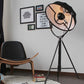 Black tripod floor lamp with angled circular shade and metal stand