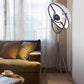 Black tripod floor lamp with textured outer shade and circular inner reflector