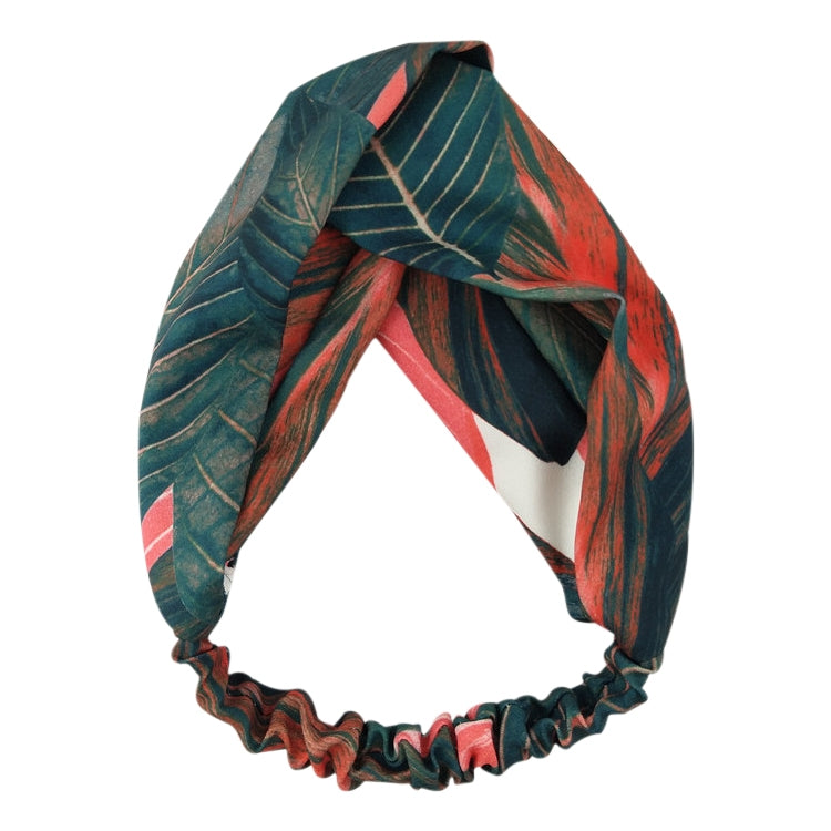 Cross-knot turban headband with teal leaves, red accents, and ruffled edge