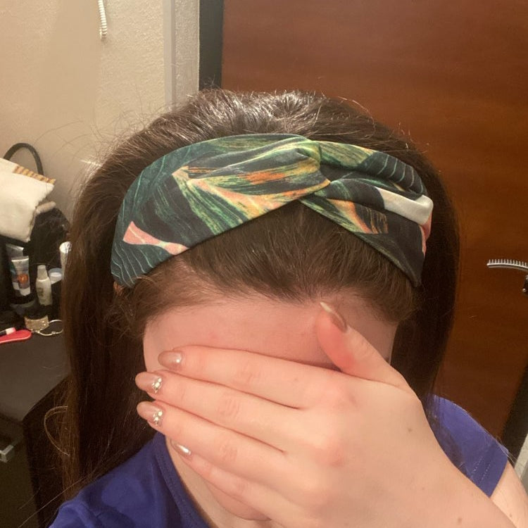 Turban headband with green and teal leaf pattern across forehead