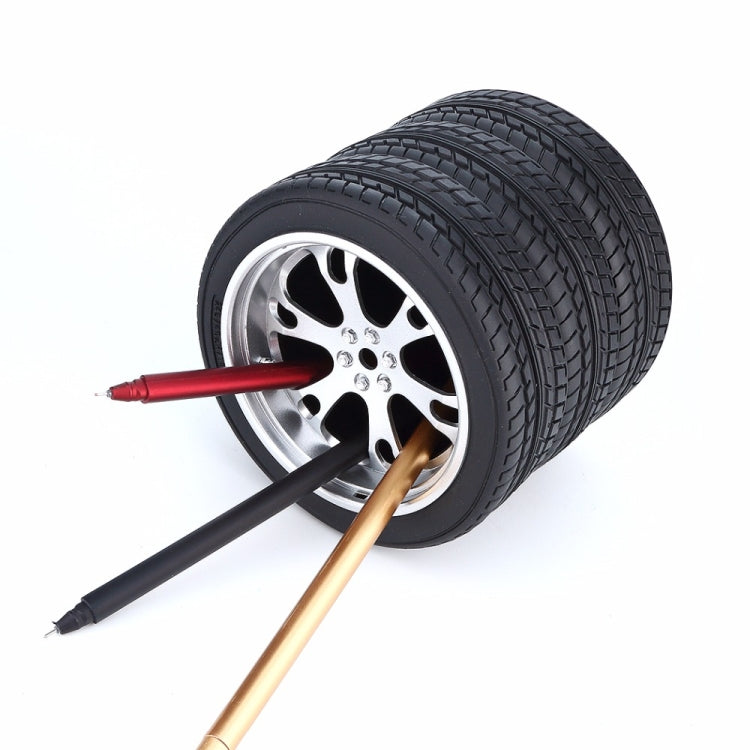 Tire wheel pen holder with red, black, and gold pens through opening