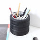 Black tire wheel pen holder with colorful pencils and pens