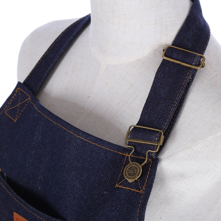 Navy denim apron straps with metal buckles and small logo charm detail.
