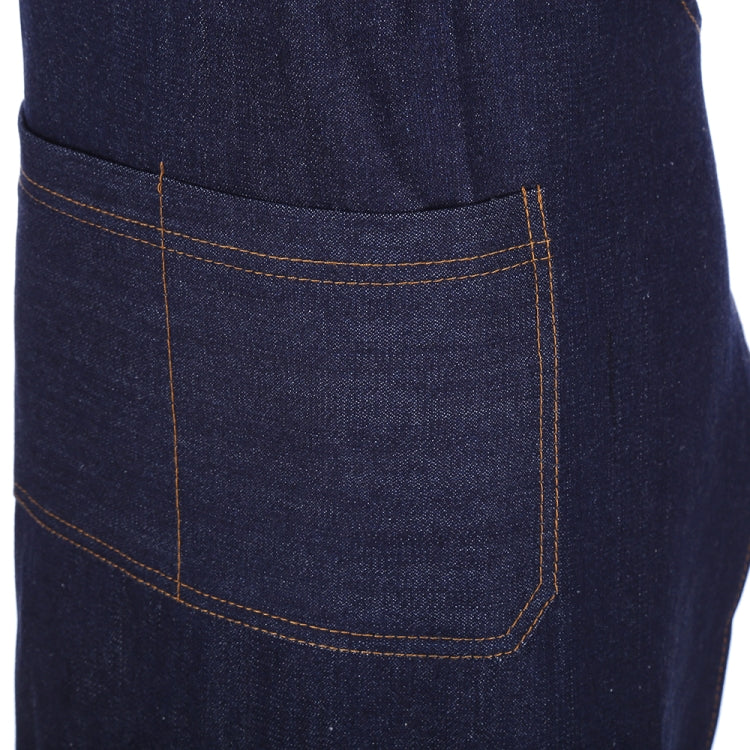 Navy denim apron front pocket with orange contrast stitching.