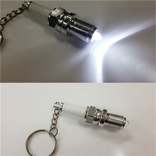Spark plug LED keychain close-up with glowing white end and metal chain