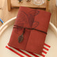 Maroon photo album cover with leaf embossing, twine tie, and hanging leaf charm.