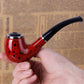 Red speckled resin mini smoking pipe with black mouthpiece, close-up in hand