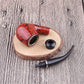 Red speckled resin pipe bowl with detachable black stem and mouthpiece on wood slice