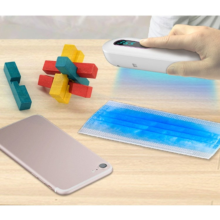 White countertop ozone disinfection box with blue display, hand using top control panel