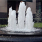 Fountain nozzle spraying multiple white water jets in a pond