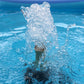 Tall water jet from fountain nozzle with visible splash and droplets