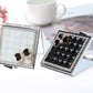 Mini folding mirror compact showing light and dark mirror panels with gem bow accents