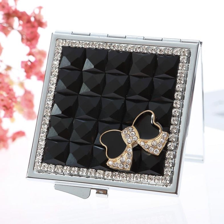 Mini folding cosmetic mirror with silver rhinestone border, dark mirror, and gem bow charm