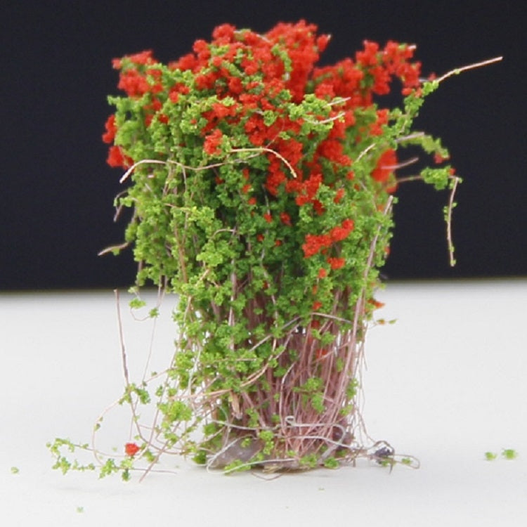 Artificial handmade model flower bush with red-orange blossoms and green foliage