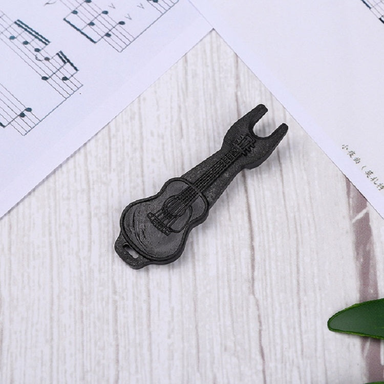 Black plastic guitar string puller tool on sheet
