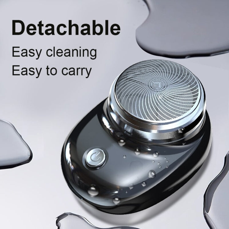 Water-resistant electric shaver with detachable head and visible water droplets.