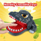 Gray dinosaur bite toy held by hand, open mouth over red base with white teeth