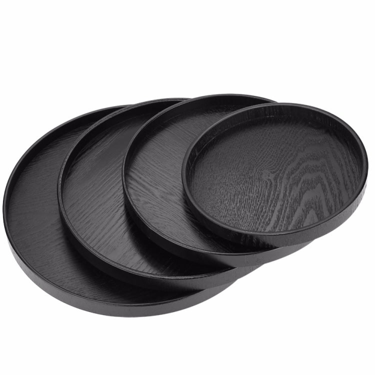 Overlapping black round wood serving trays, nested stack with raised borders