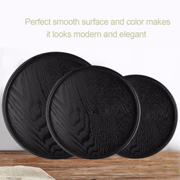 Three black round wood trays stacked, dark woodgrain finish on smooth raised surfaces