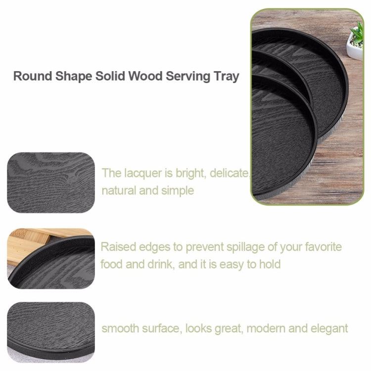 Black round wooden serving tray set, nested with raised lip along the rim