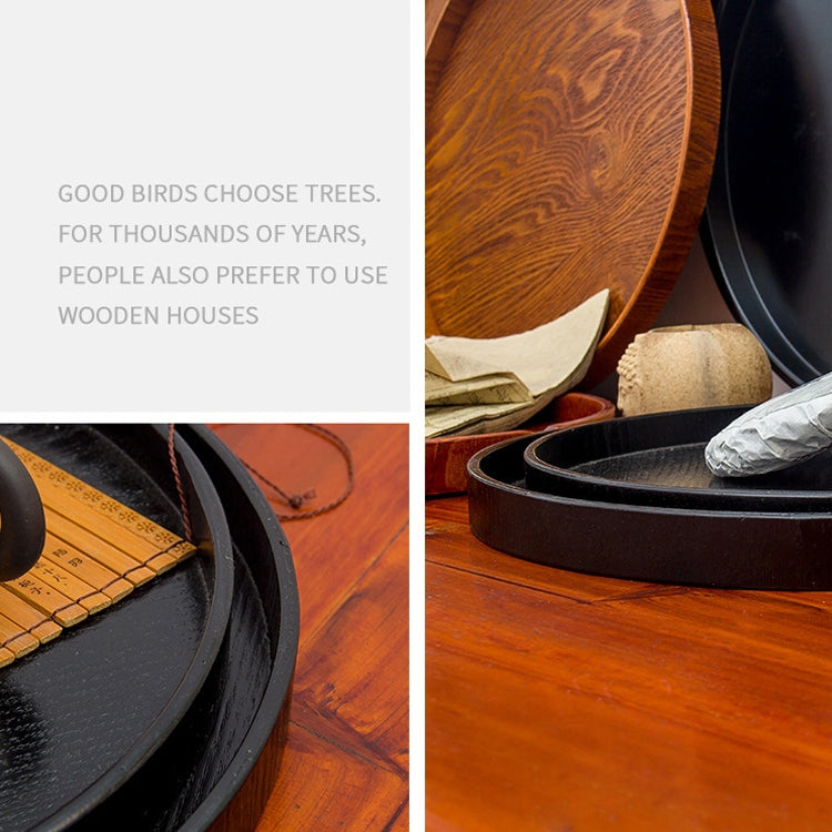 Black round wood tray with raised rim, shown from the side with stacked trays