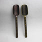Pair of dark metal tea spoons with gold filigree handles and swirl bowls