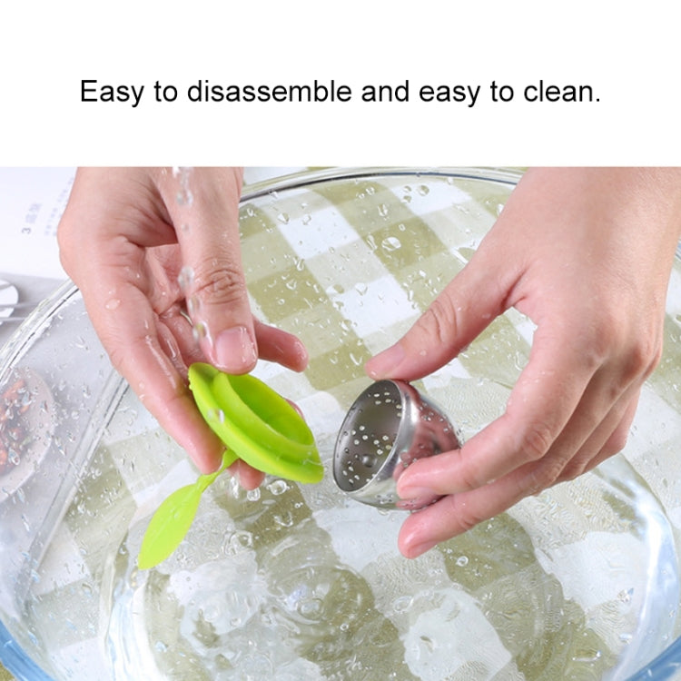 Green silicone leaf tea bag strainer holder with stainless basket during cleaning