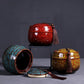 Ceramic mini tea storage set in red, teal, and yellow with tassel pulls.