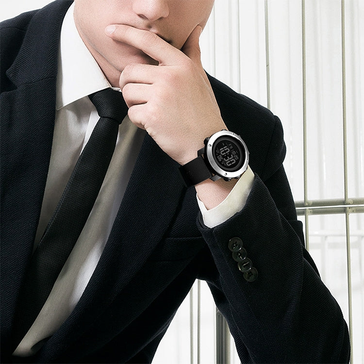 Digital outdoor wristwatch worn on a man’s wrist, black case and dark rubber strap