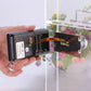 Hand installing digital door viewer security camera module near door peephole