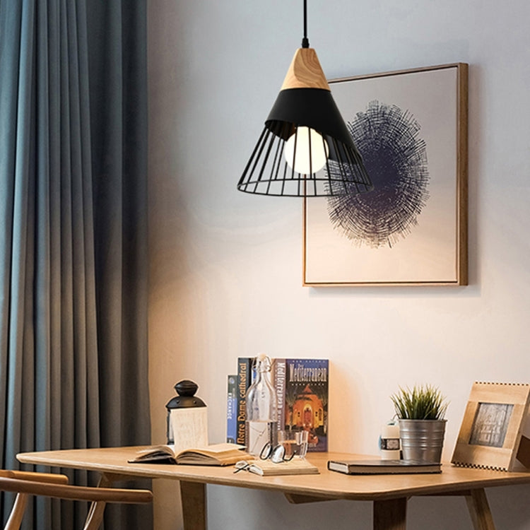 Modern pendant light with black metal cage shade, wood cap, and glowing bulb.