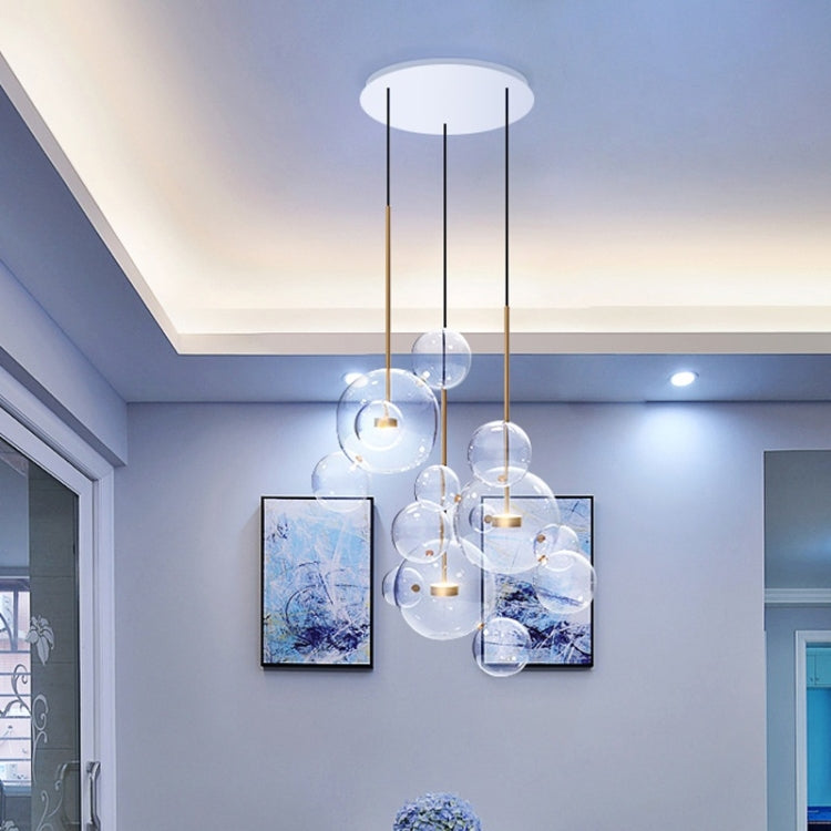 Glass ball chandelier with clear globe shades and gold hanging stems on ceiling