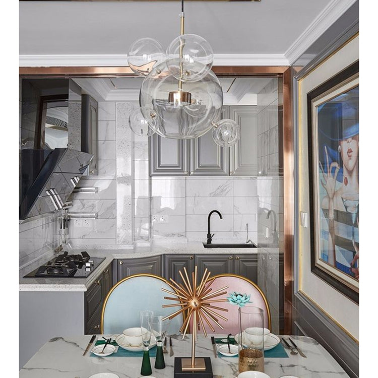 Glass globe chandelier with clear spheres and gold hanging rods