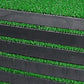 Close-up of layered dark foam edges on a green golf practice mat
