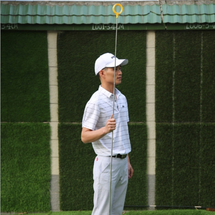 Golf ball catcher held by golfer, yellow hoop with extended pole and spring
