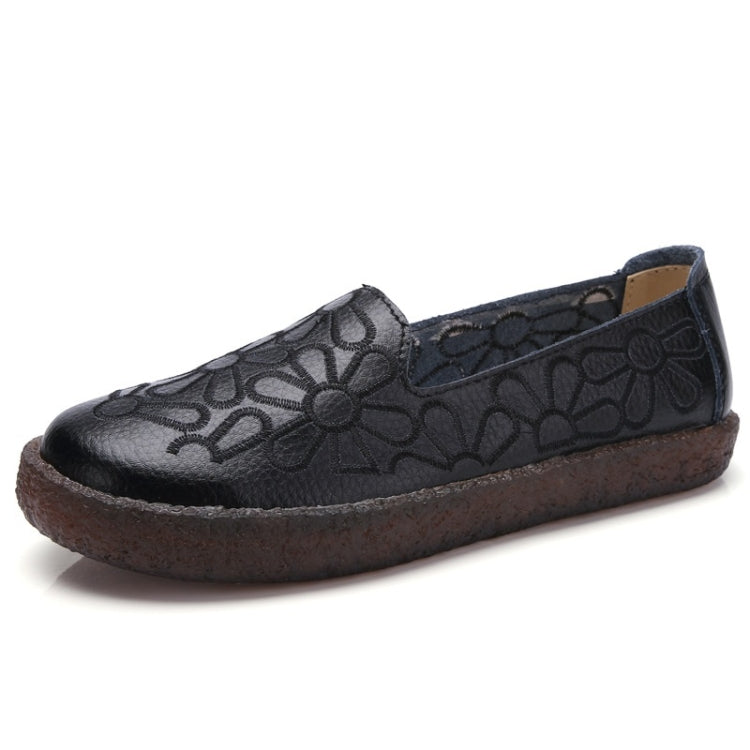 Women's dark embroidered slip-on casual shoes with floral embossing and brown sole.