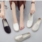 Women's floral-embossed slip-on flats in white and dark, shown with feet and spare pair.