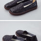 Women's dark embroidered slip-on flats with floral embossed pattern and brown rubber sole.