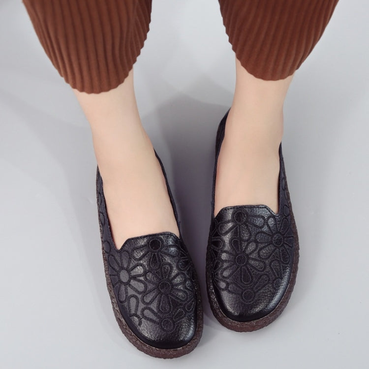 Women's black embroidered casual slip-on shoes with floral embossed details.