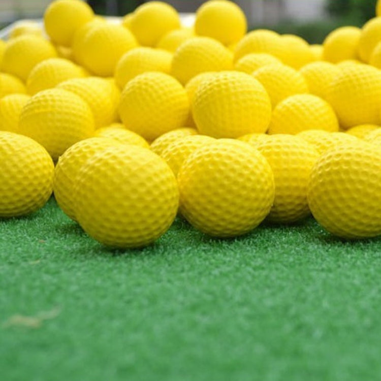 Set of yellow indoor golf rubber balls on green turf