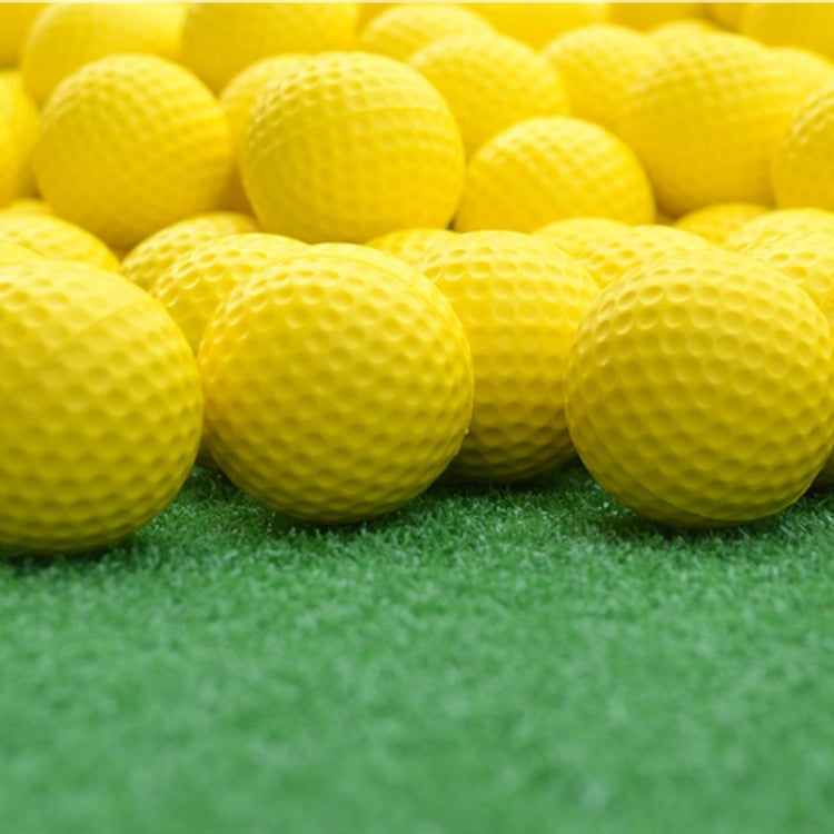 Yellow indoor golf rubber balls on turf, close grouped view