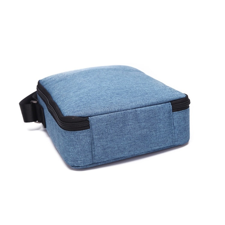 Blue fabric zippered compact case with shoulder strap and rounded top flap.