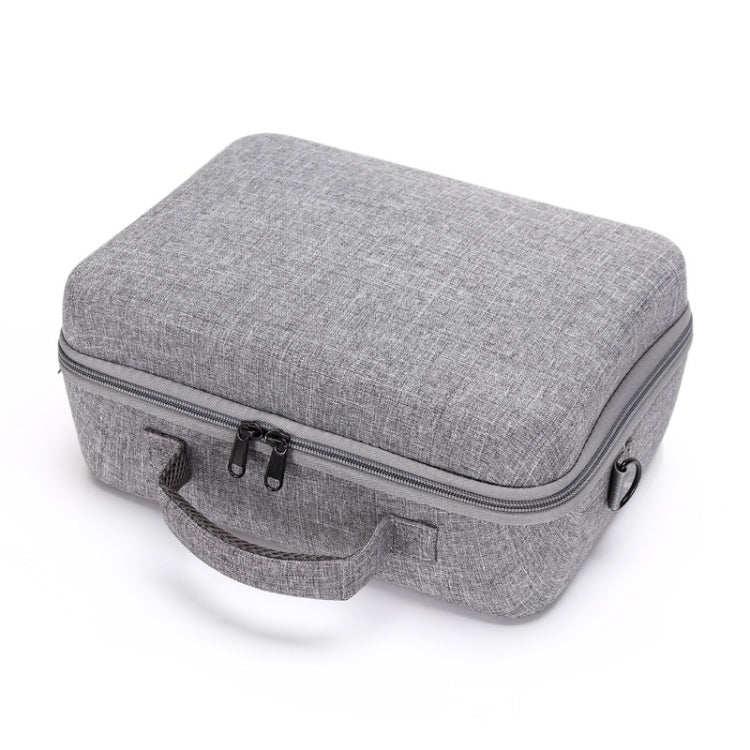 Gray compact carry case with top lid, zipper closure, and front strap tabs.