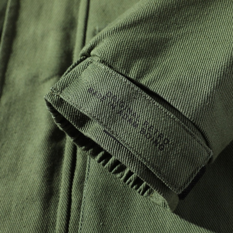 Green corduroy-style jacket sleeve cuff with rib trim and stitched seam