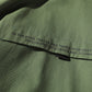 Green jacket front with zip closure and small black logo pull tab