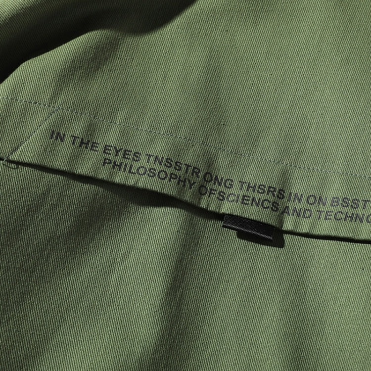 Green jacket front with zip closure and small black logo pull tab