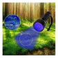 Black UV flashlight with purple UV beam aimed at outdoor grass